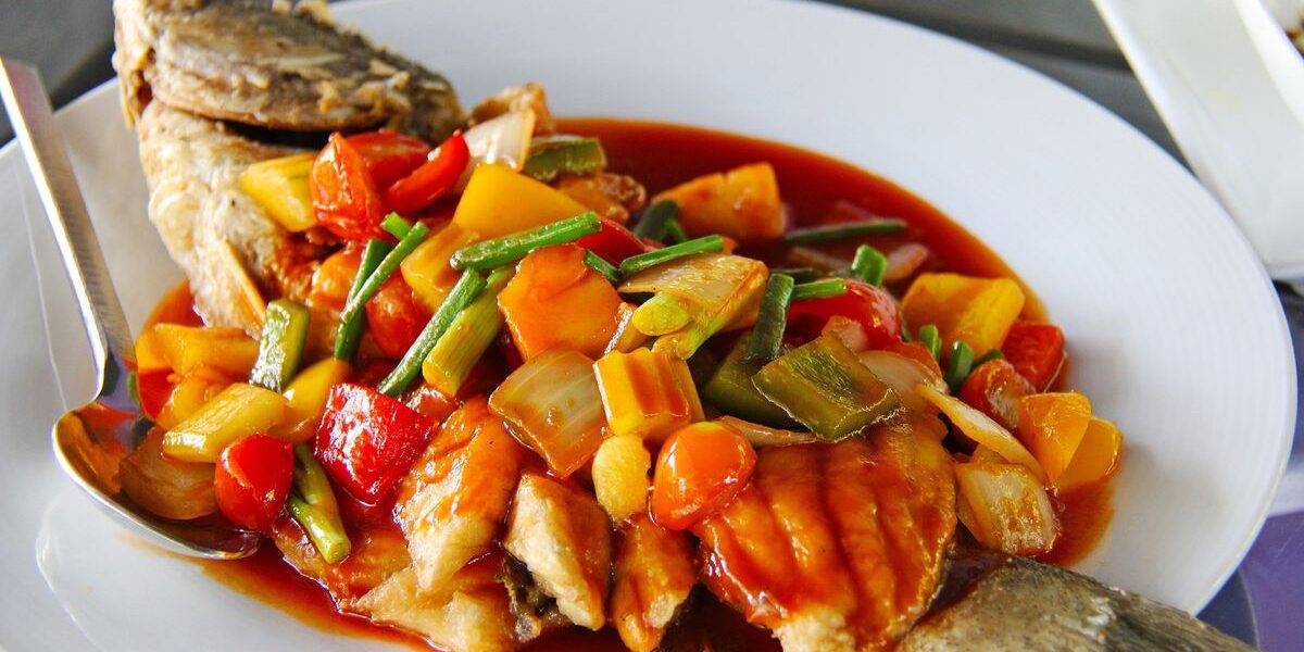 Sepiring ikan nila asam manis dengan saus kental berwarna merah menggoda
